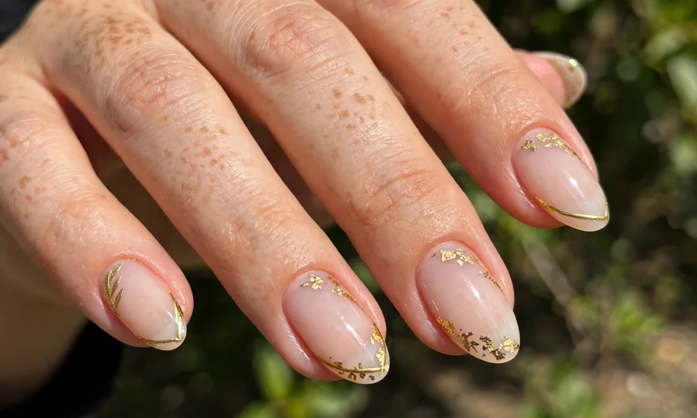 Short almond acrylic nails with gold accents